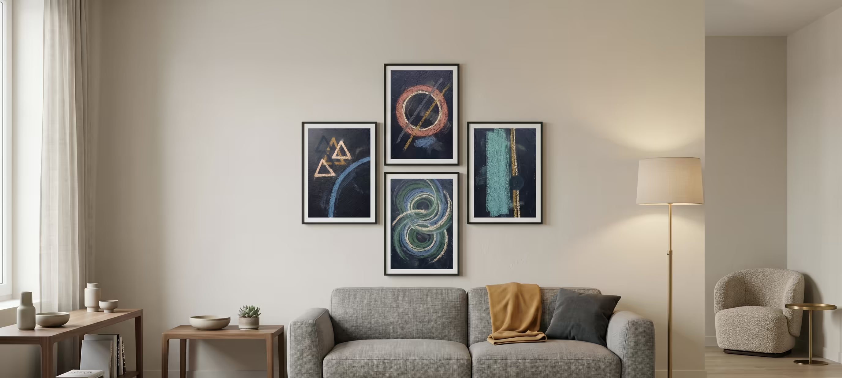 A modern living room scene featuring a set of four framed abstract art prints in black, blue, and teal tones, styled above a gray sofa.