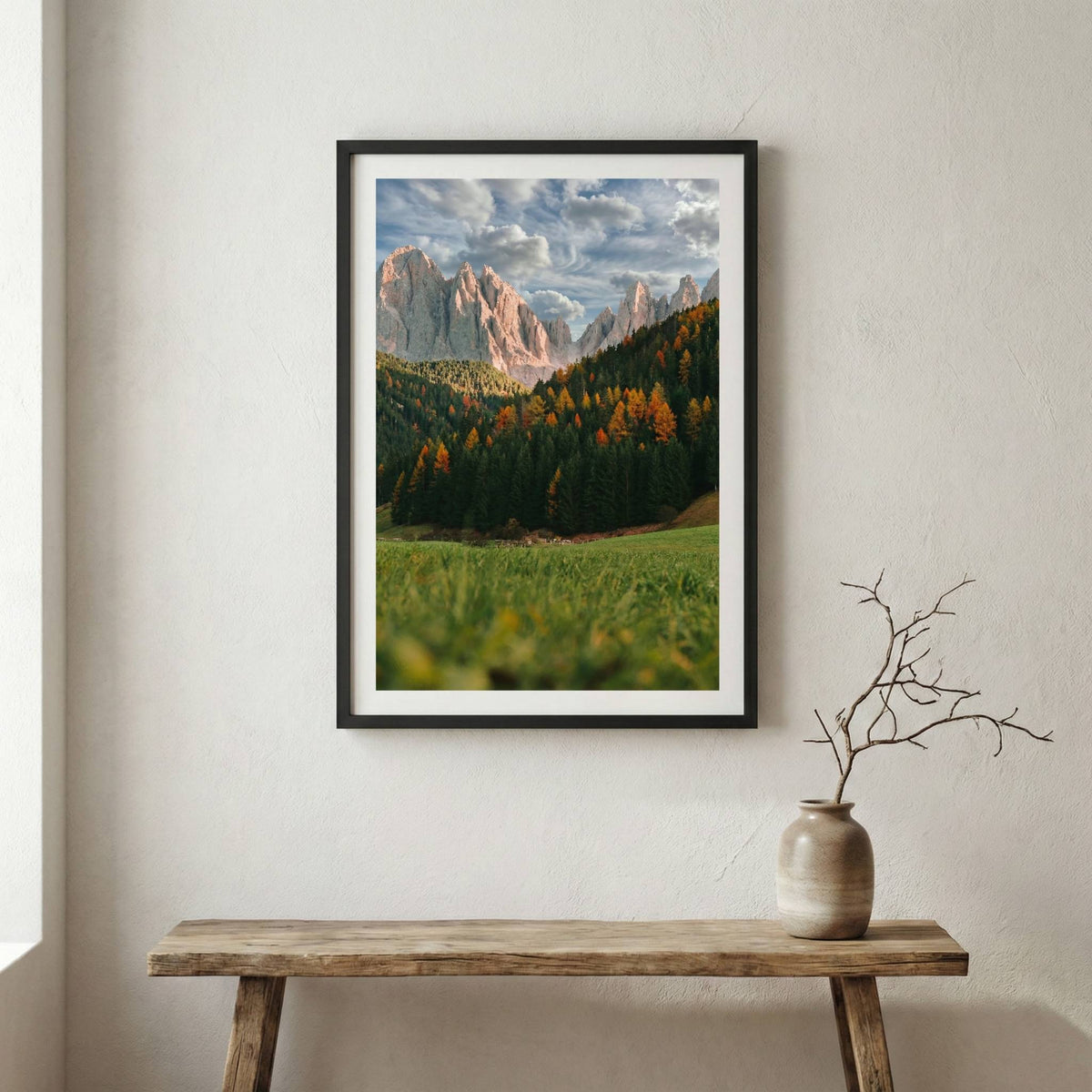 Jagged alpine peaks rising above a green valley dotted with autumn-colored trees — wooden frame canvas wall art print, 12×18 in