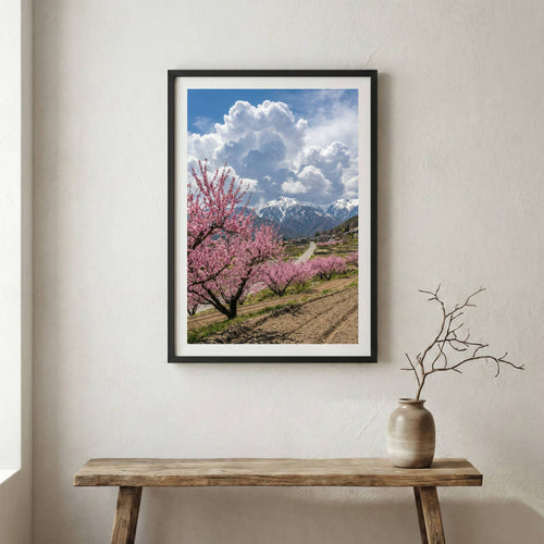 Blossoming trees lining a hillside path under a bright, cloud-filled blue sky — wooden frame canvas wall art print, 12×18 in