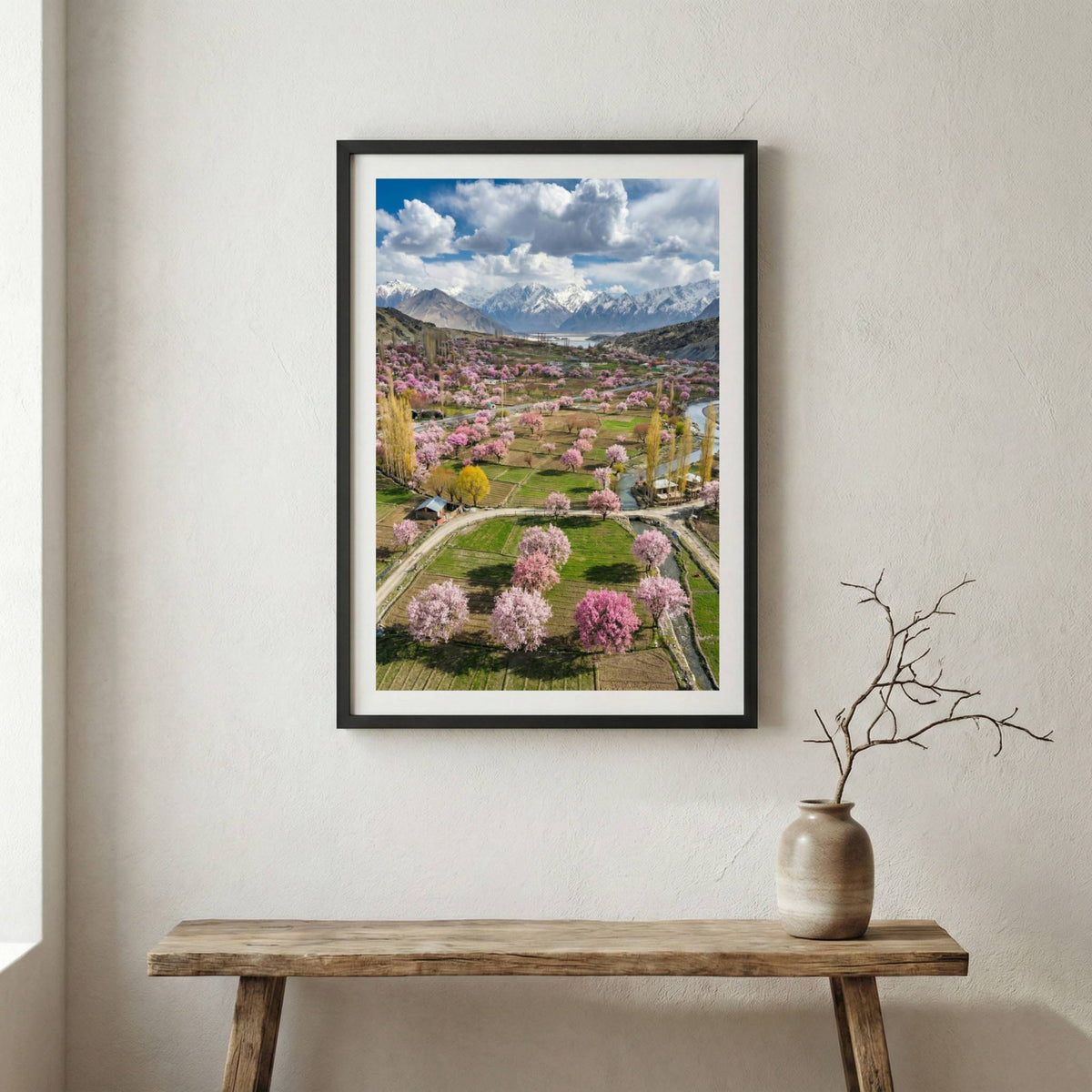 Aerial view of a valley in full bloom with pink blossom trees and a mountain backdrop — wooden frame canvas wall art print, 12×18 in