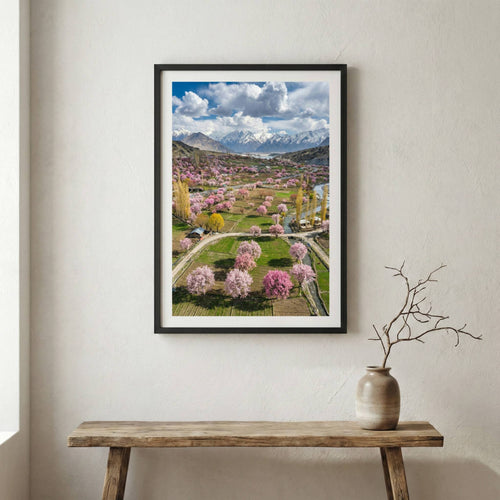 Aerial view of a valley in full bloom with pink blossom trees and a mountain backdrop — wooden frame canvas wall art print, 12×18 in