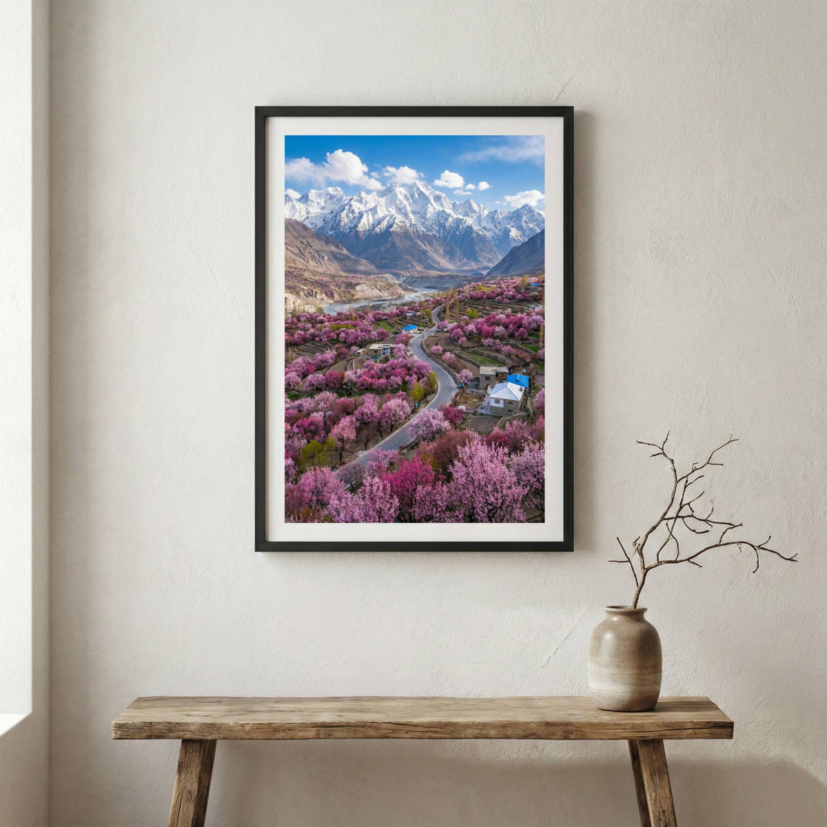 Aerial view of a blossoming valley with a road and a snow-capped mountain beyond — wooden frame canvas wall art print, 12×18 in