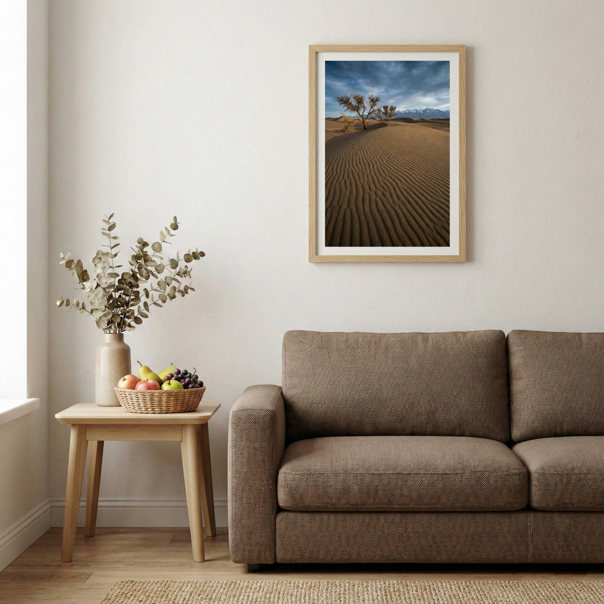 Lone bare tree on rippled desert dunes with distant snow-capped mountains — wooden-frame wall art print, 20×30 in