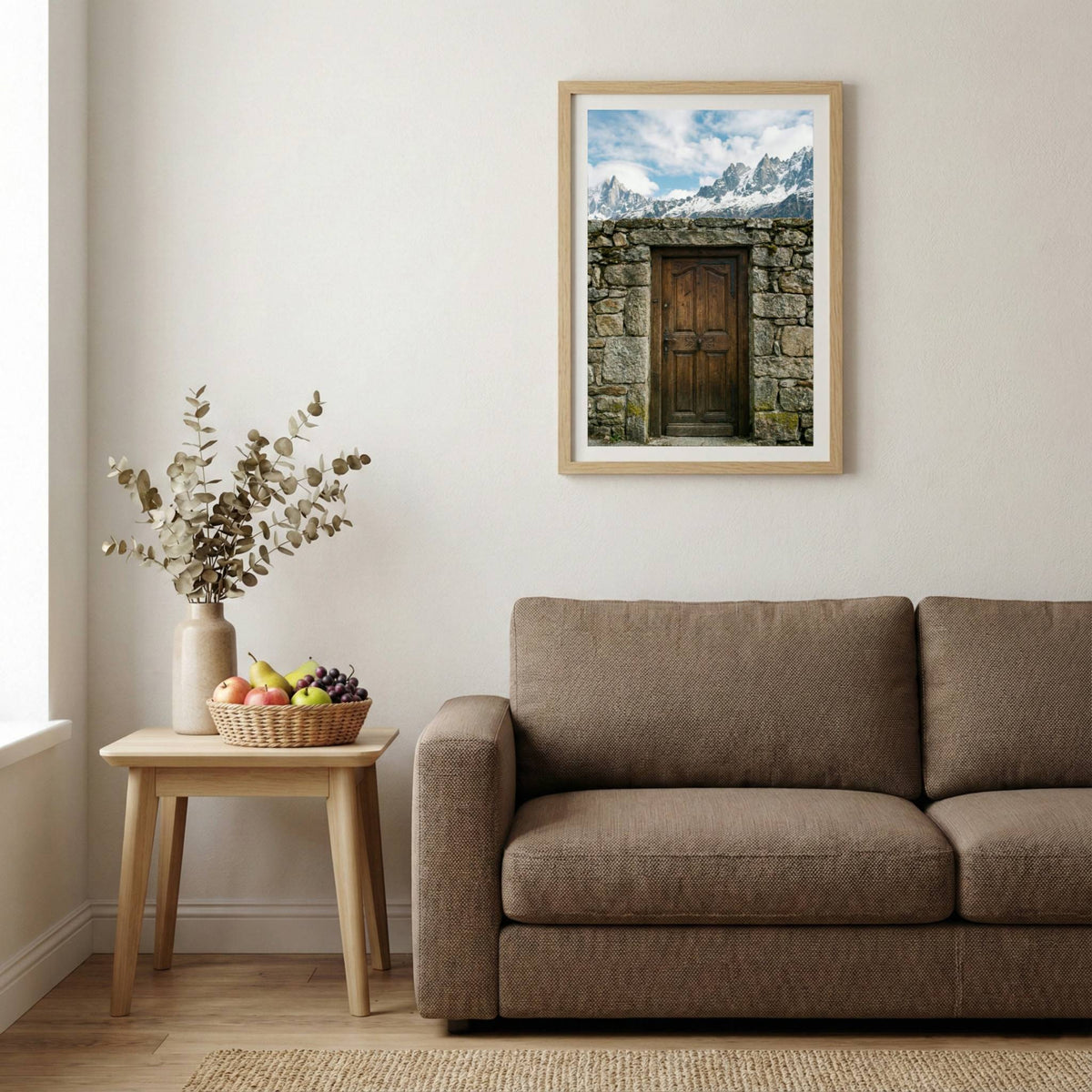 Rustic wooden door in a stone archway framing a view of snow-capped mountain peaks — wooden-frame wall art print, 20×30 in