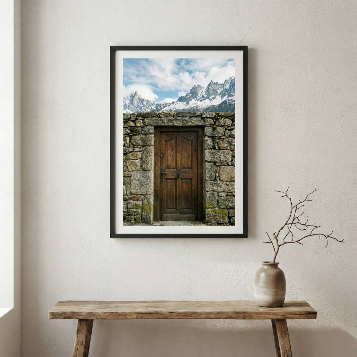 Rustic wooden door in a stone archway framing a view of snow-capped mountain peaks — wooden frame canvas wall art print, 12×18 in