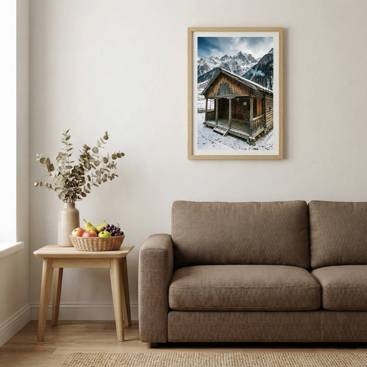 Snow-covered wooden cabin set against jagged, snow-capped mountains — wooden-frame wall art print, 20×30 in