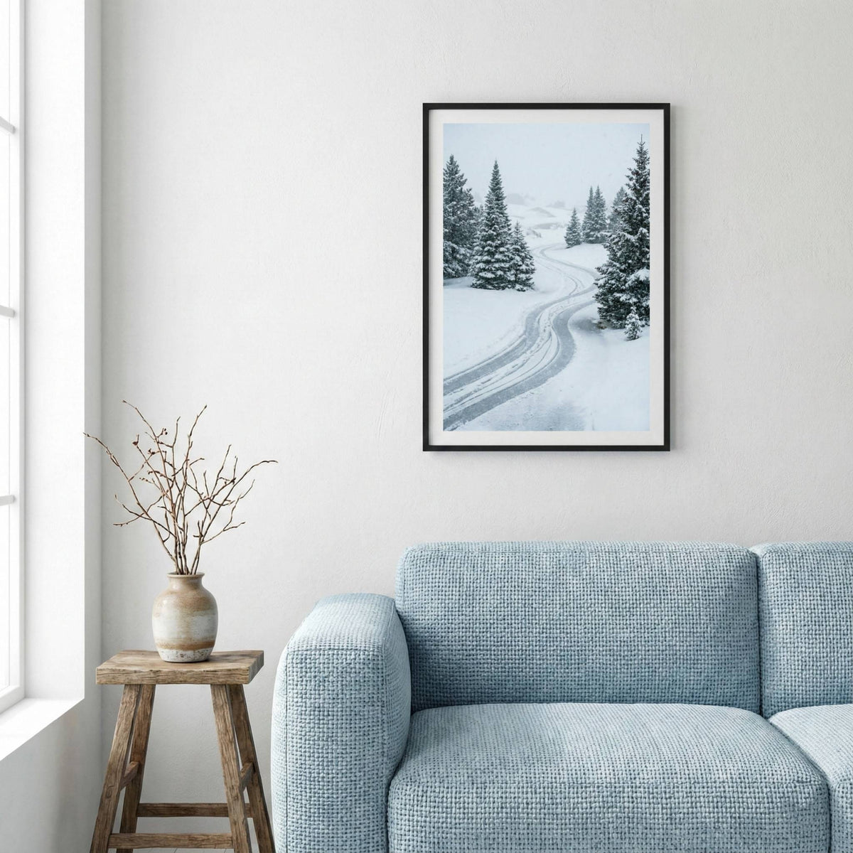 Snow-covered pine trees lining a winding winter road — framed canvas wall art in a wooden frame, 16×24 in