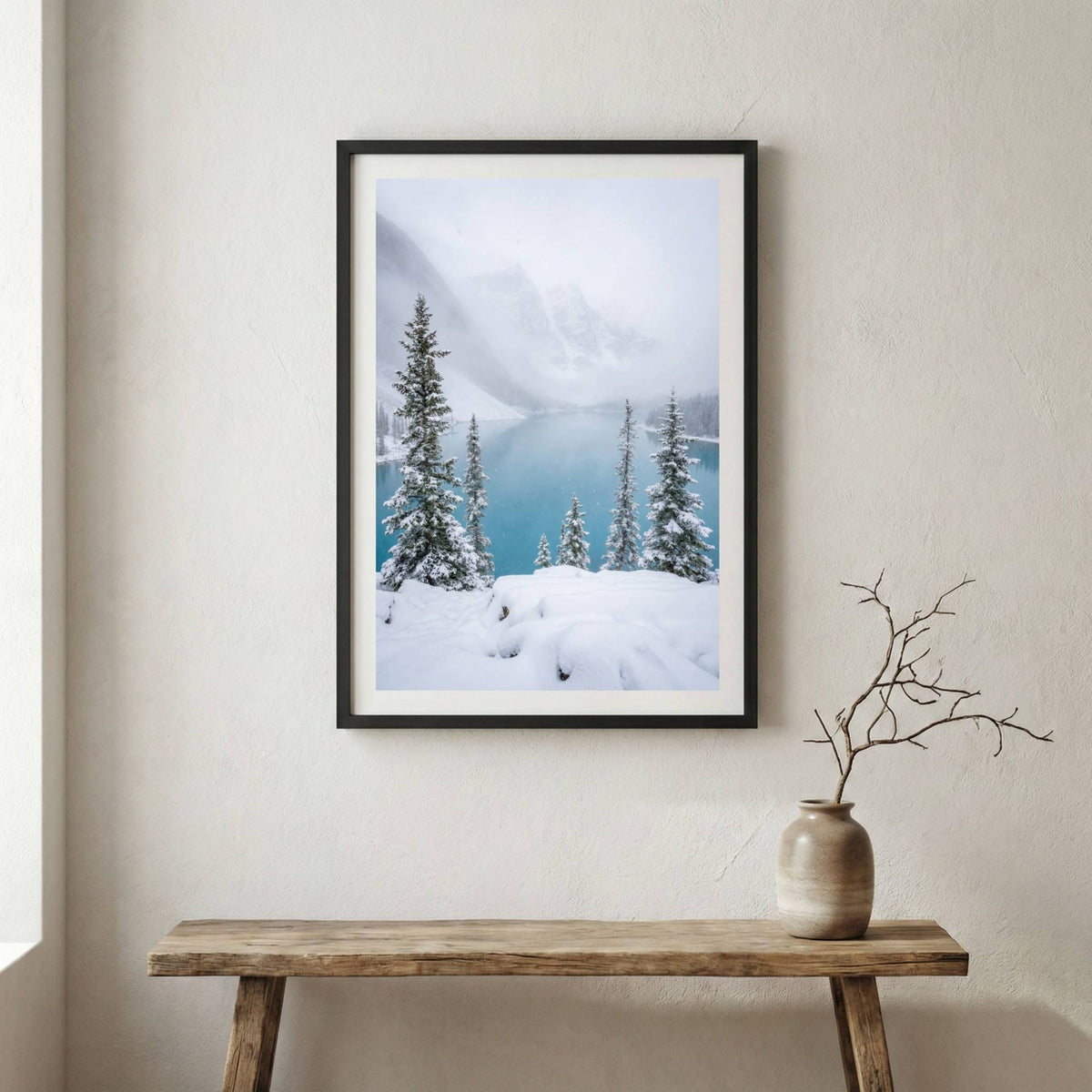 Snow-dusted pine trees on a ledge overlooking a misty turquoise lake — wooden frame canvas wall art print, 12×18 in