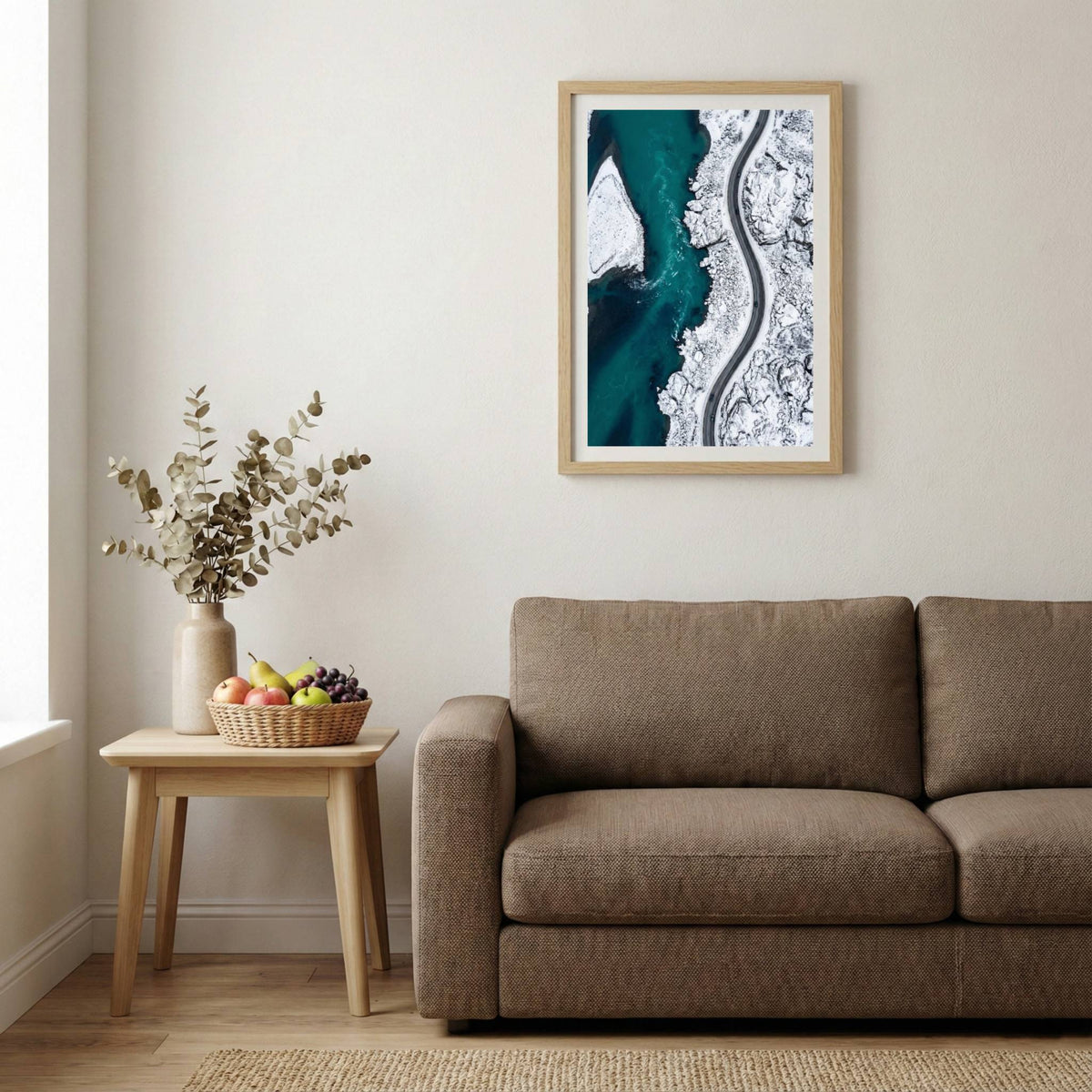 Aerial view of turquoise water meeting a snow-covered coastline and winding road — wooden-frame wall art print, 20×30 in