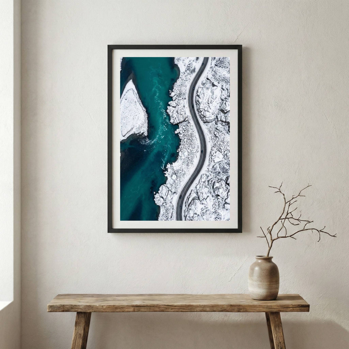 Aerial view of turquoise water meeting a snow-covered coastline and winding road — wooden frame canvas wall art print, 12×18 in