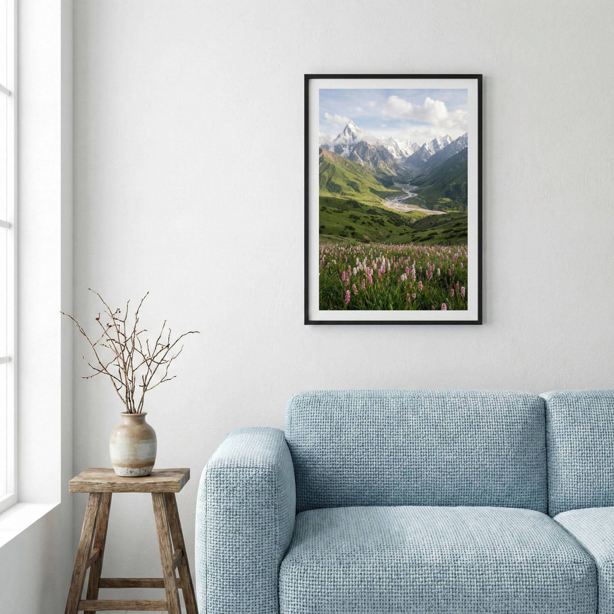 Green river valley with purple wildflowers in the foreground and snow-capped peaks beyond — framed canvas wall art in a wooden frame, 16×24 in