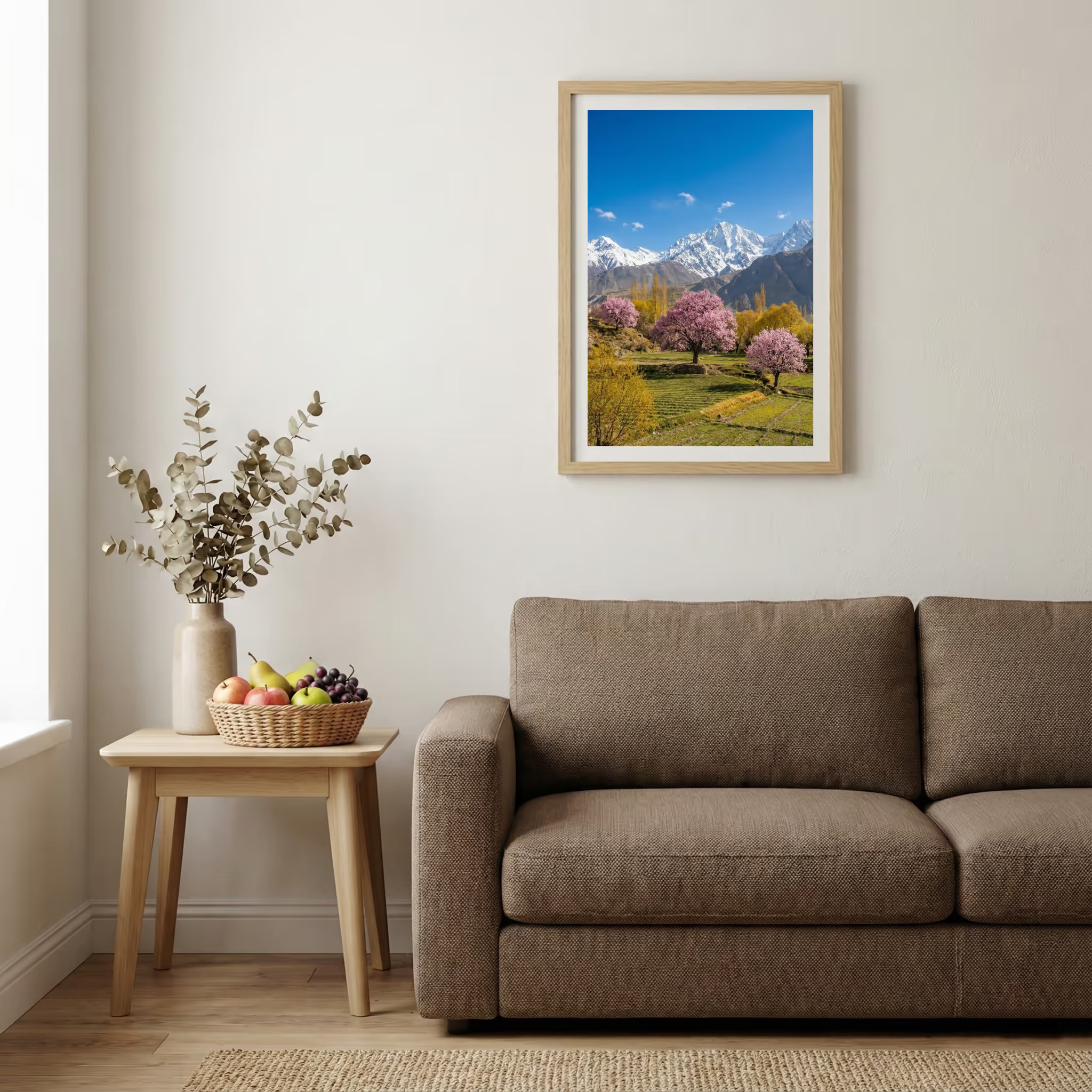Pink blossom trees in a green meadow beneath snow-capped mountain peaks — wooden-frame wall art print, 20×30 in